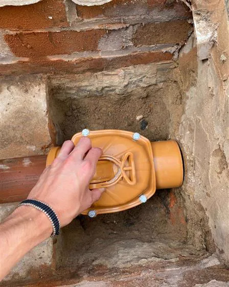 Fitting a non-return valve in a brick drainage chamber