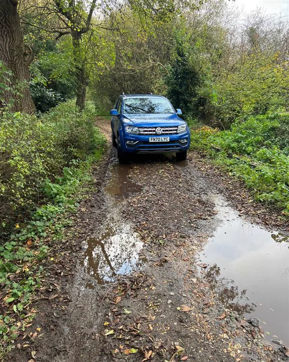 A pick-up truck on a flooded woodland track during a site visit