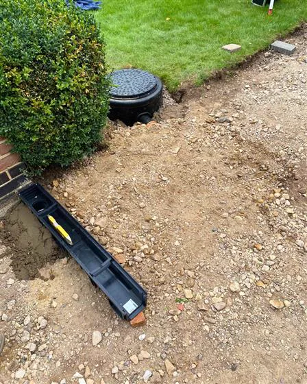 A channel drain and inspection chamber being installed