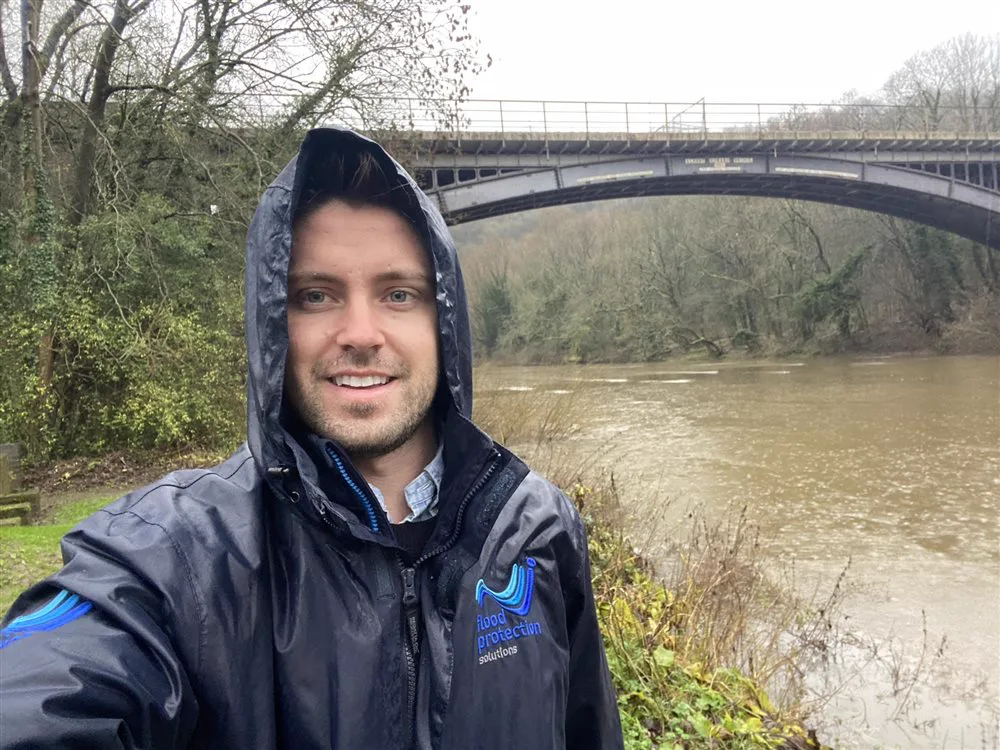 Simon Crowther on a site inspection beside a river in spate