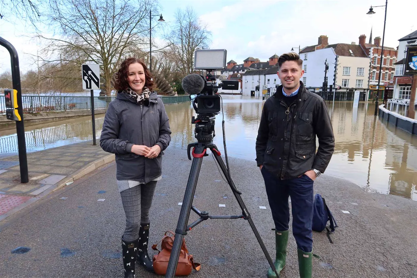 Simon Crowther filming a flood-risk report for television beside a flooded street